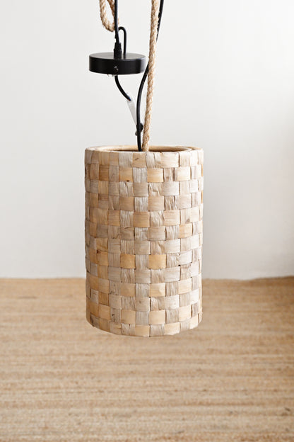 Pendant light with woven wooden shade on a neutral background
