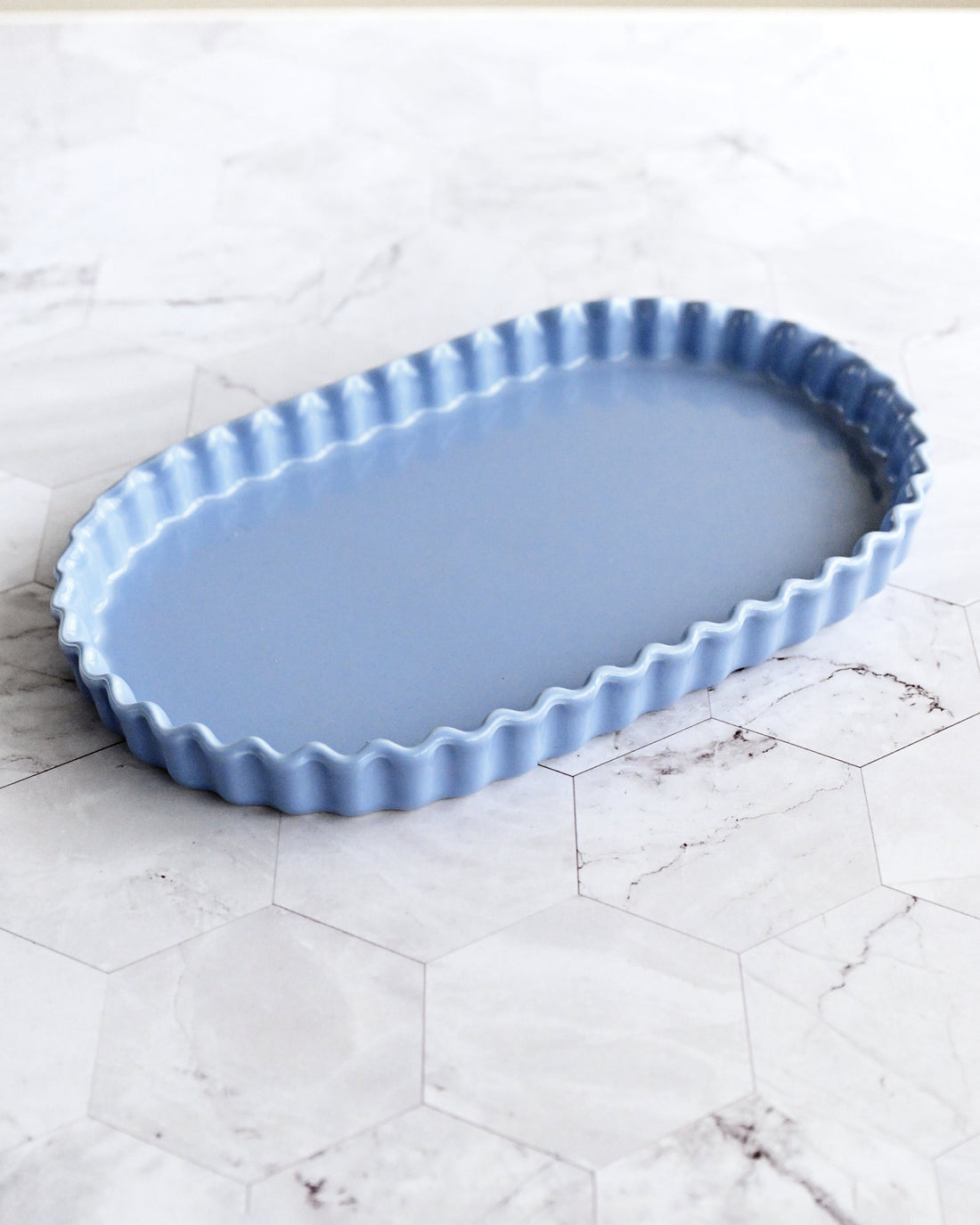 Blue ceramic baking dish on a white marble surface