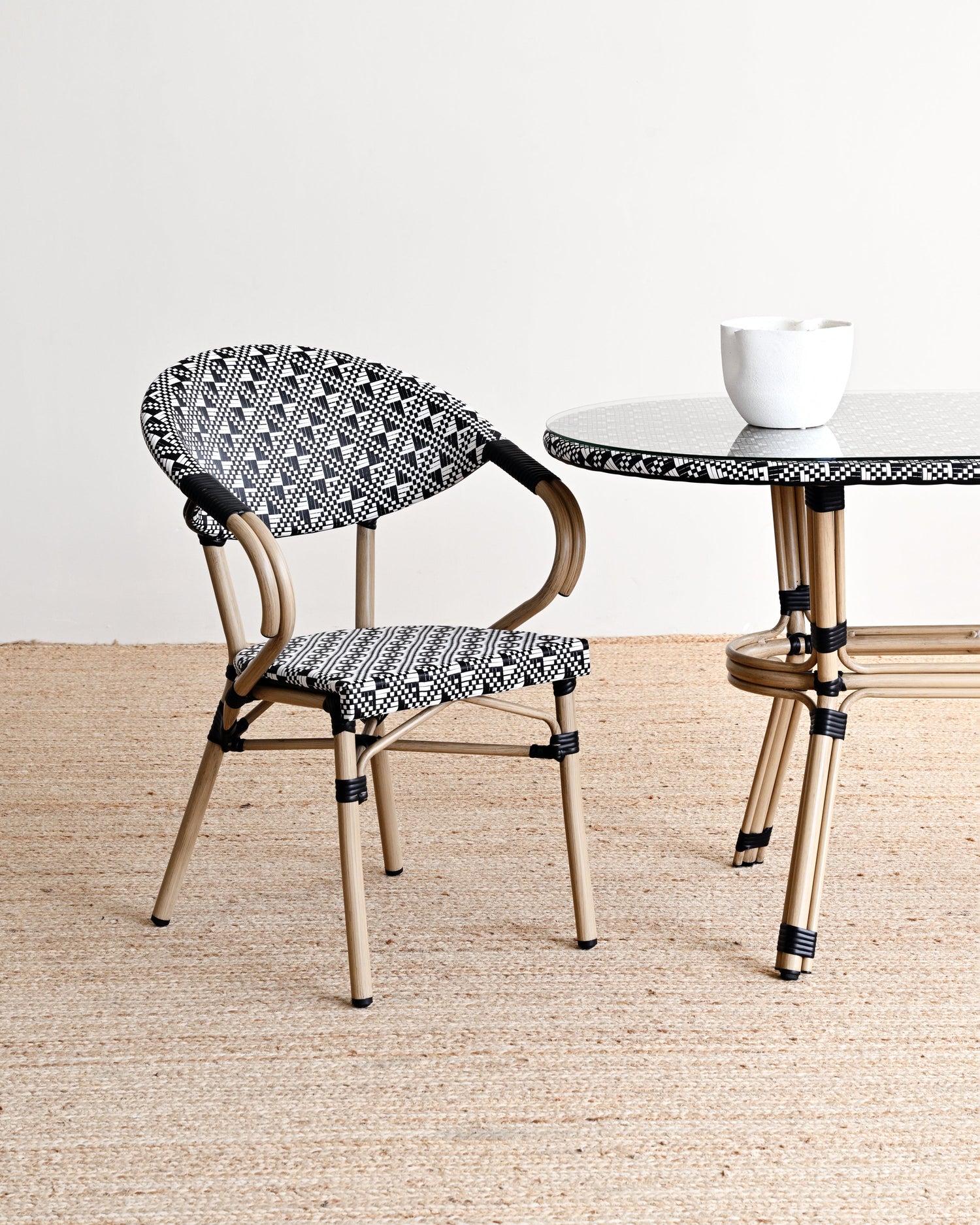 Chair and table with black and white patterned seats and legs on a neutral background