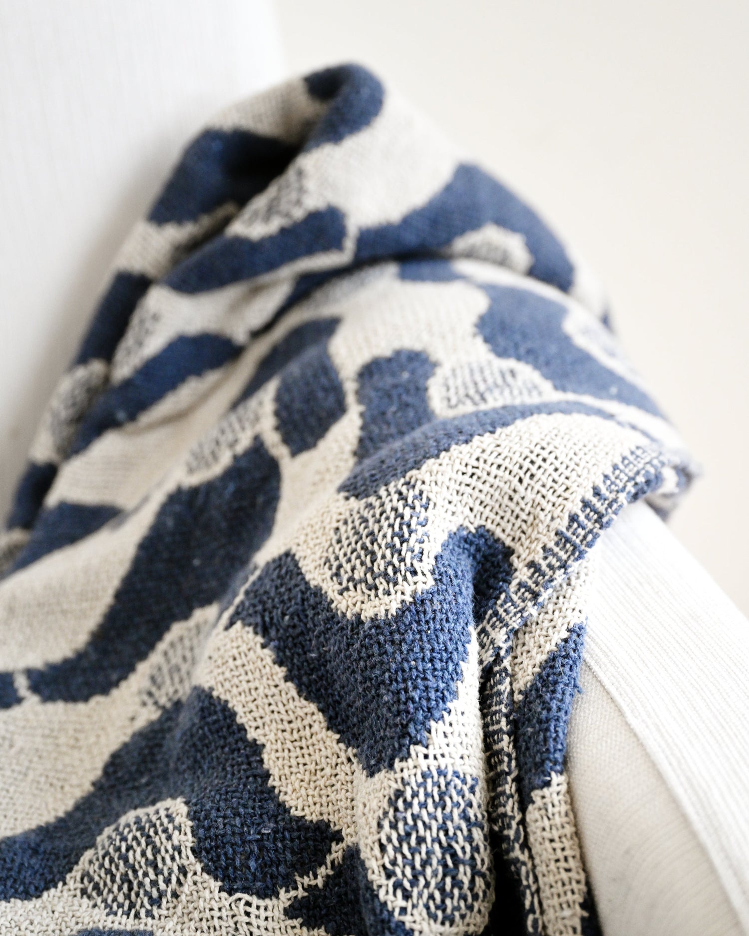 Blue and white patterned fabric draped over a white surface