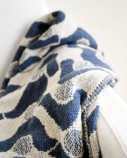 Blue and white patterned fabric draped over a white surface