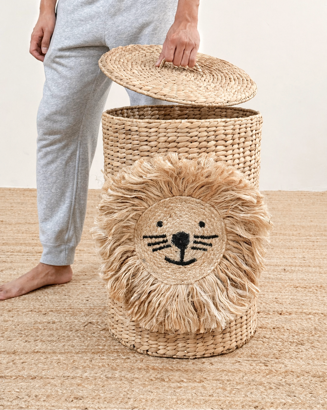Wicker laundry basket with lion design on a wooden floor