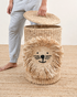 Wicker laundry basket with lion design on a wooden floor