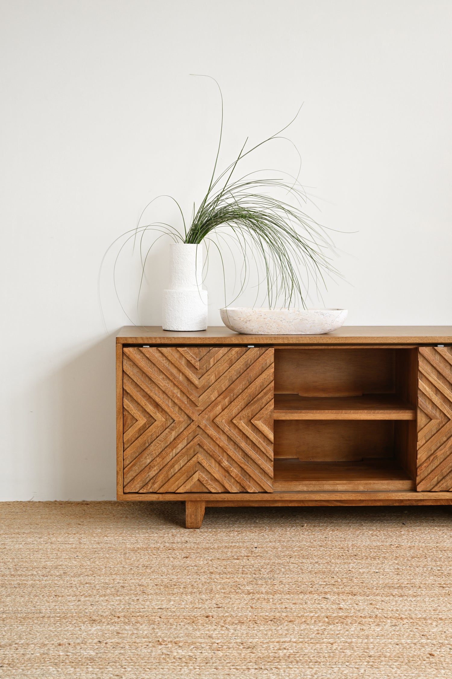 Wooden sideboard with geometric design on a white wall background