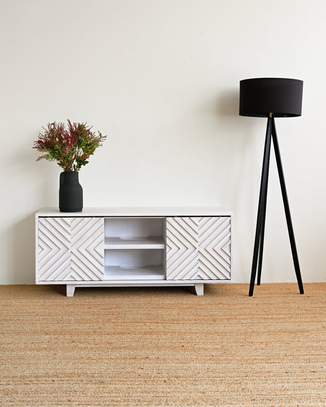 White textured cabinet with a black lamp and plant on a beige carpet