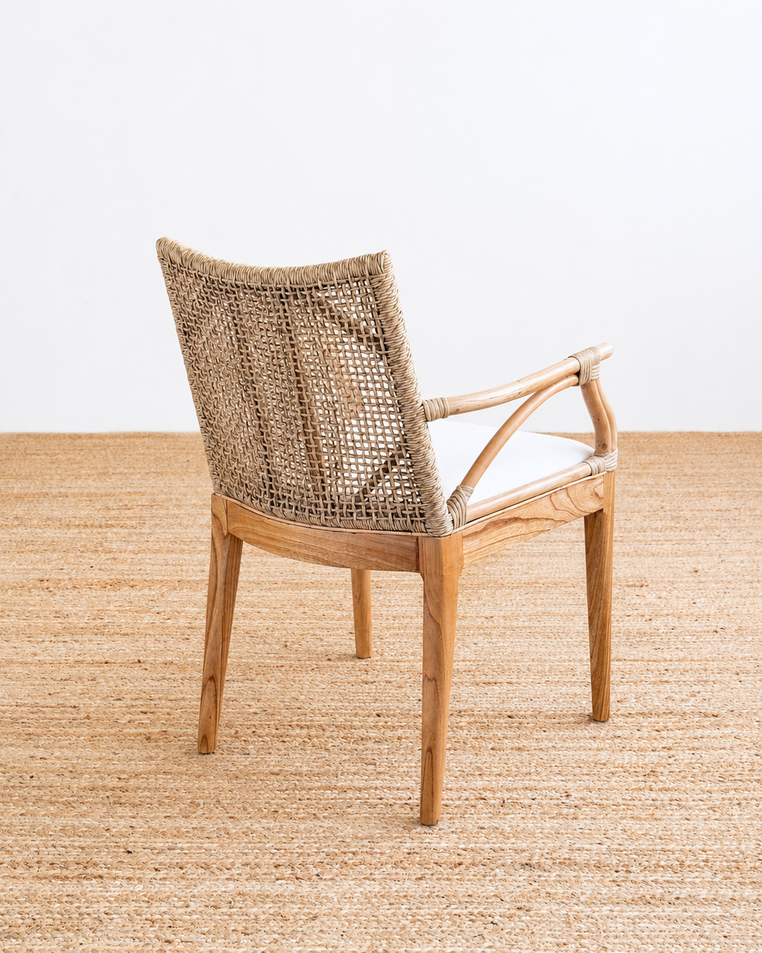 Wicker chair on a textured beige surface with a neutral background