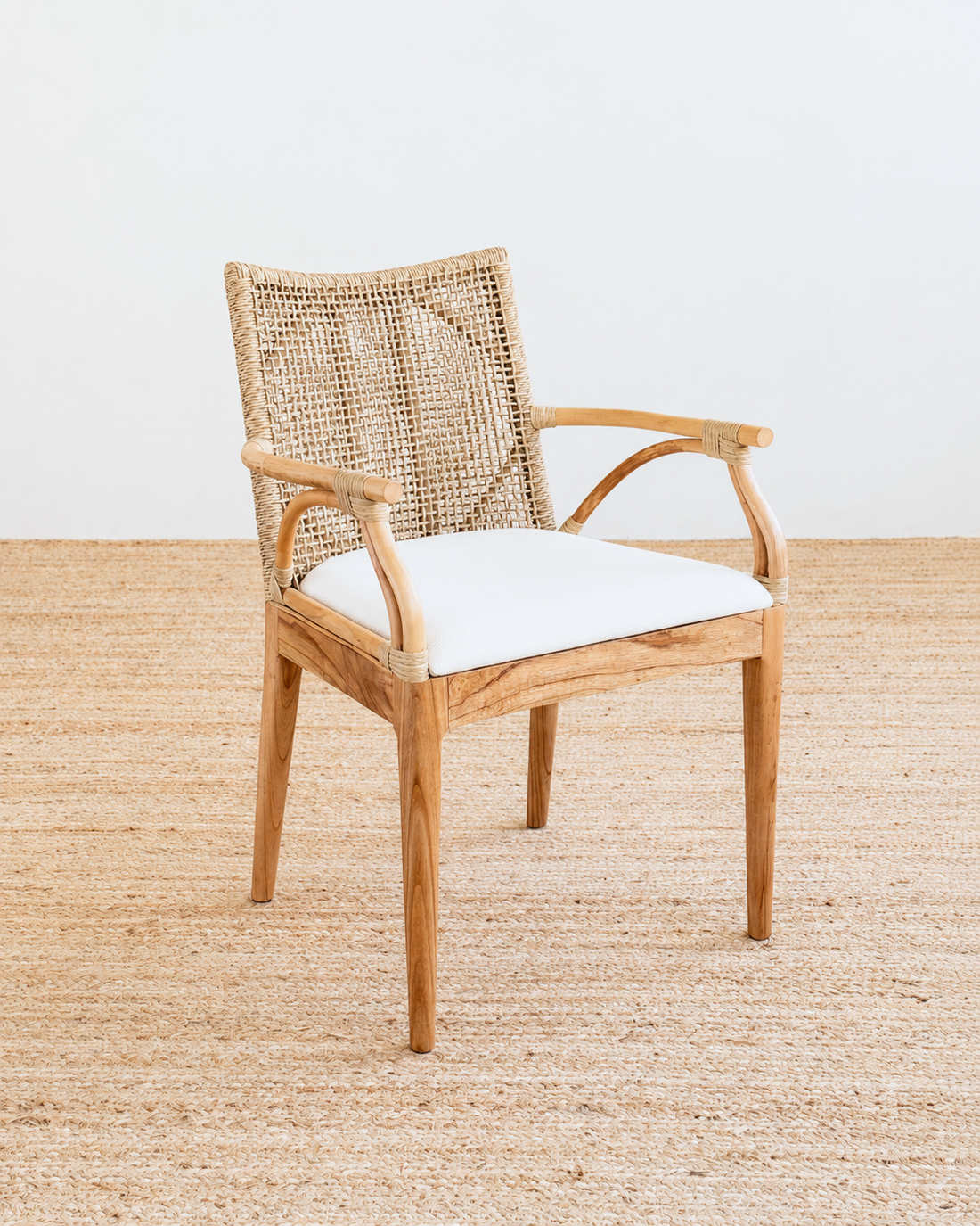Woven chair with a white cushion on a textured floor