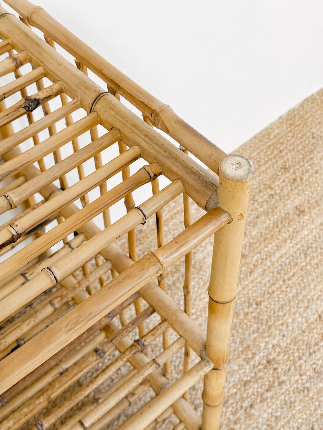 Close-up of a bamboo shelf with a textured beige background