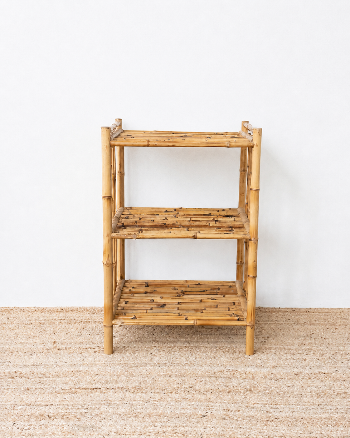 Bamboo shelf against a white wall on a textured floor