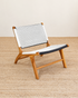 Wooden chair with a black and white patterned backrest on a beige floor.