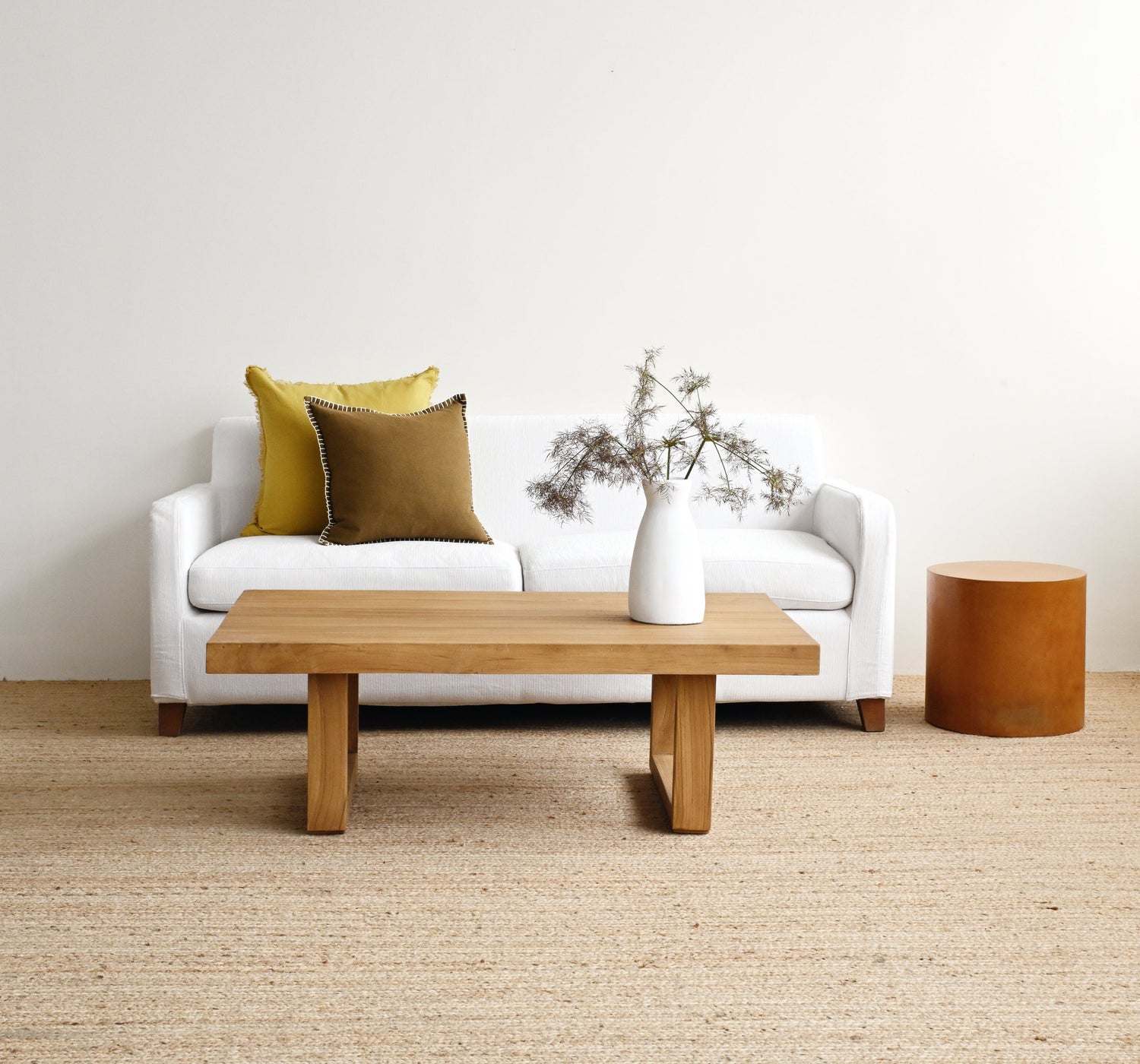 Modern living room with a white sofa, wooden coffee table, and decorative elements.