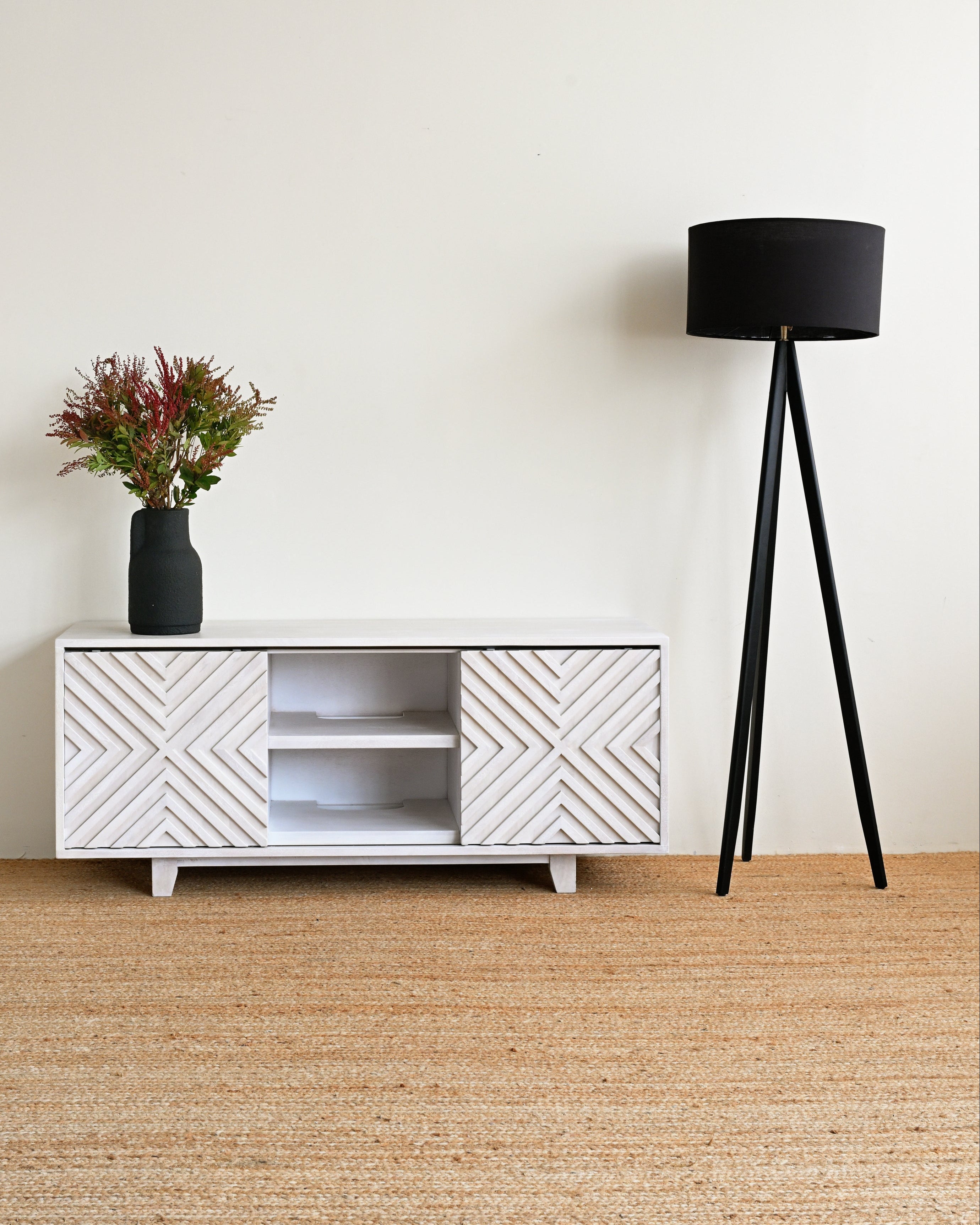 White textured cabinet with a black lamp and plant on a beige carpet