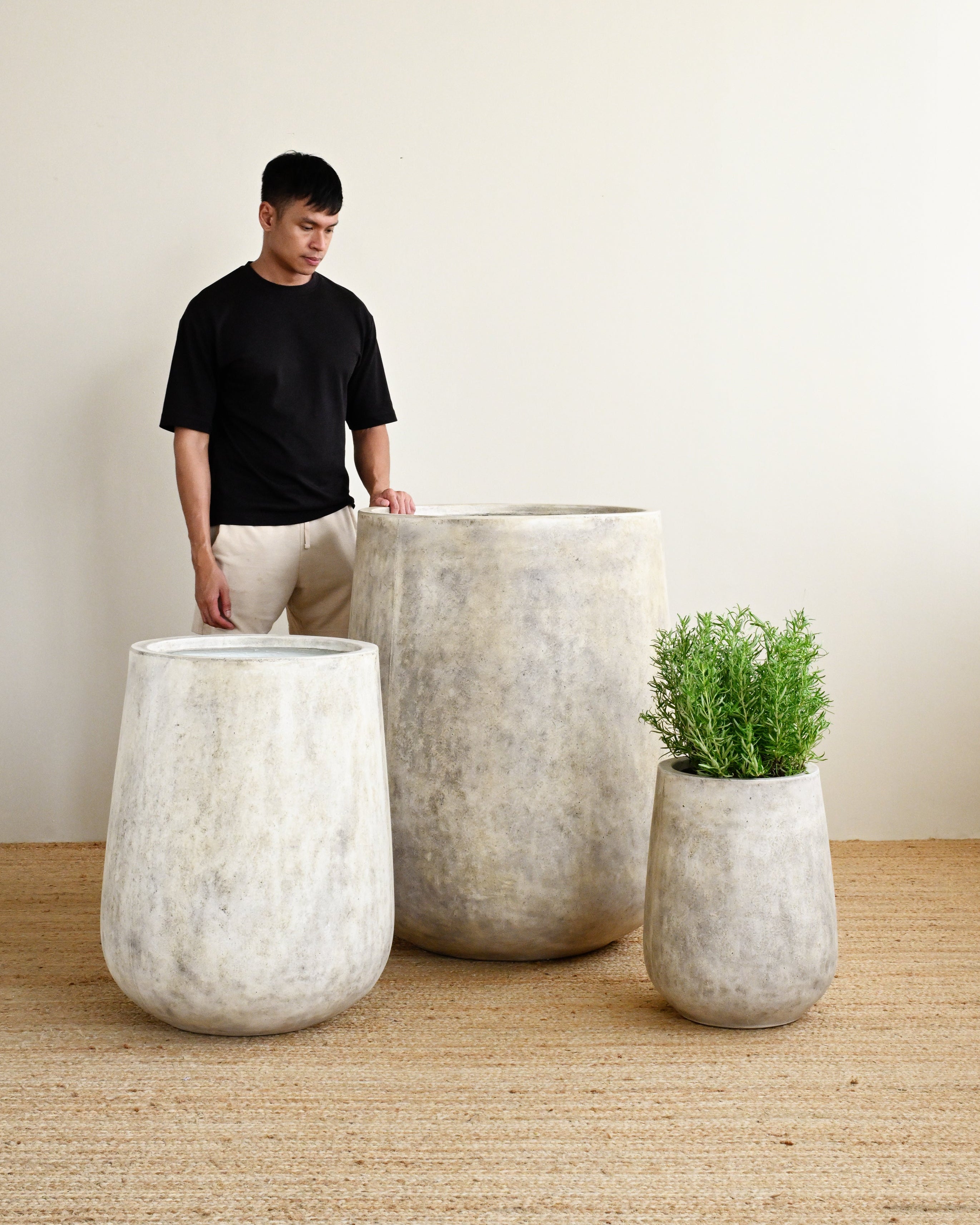 Man standing with 3 stylish concrete planters in rustic textured finish