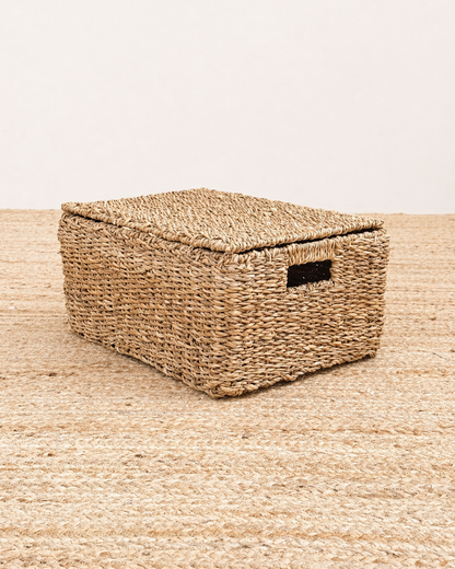 Woven storage basket with a lid on a matching woven surface