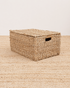 Woven storage basket with a lid on a matching woven surface