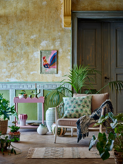 Living room with a sofa, plants, and a fireplace.