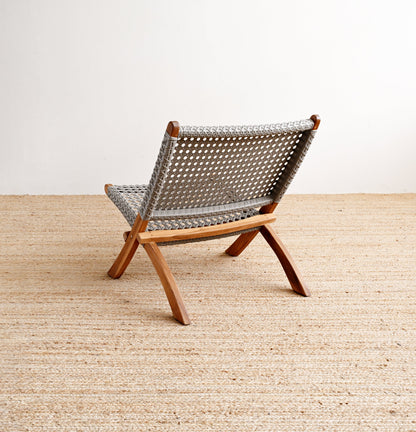 Woven chair on a wooden floor with a white wall background