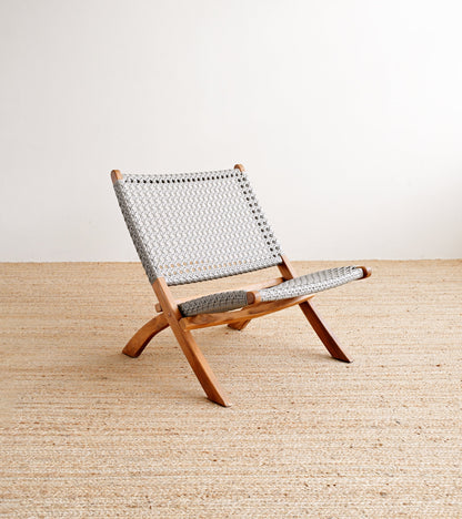 Wooden chair with woven seat and backrest on a beige floor.