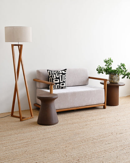 Modern living room with a gray sofa, wooden floor lamp, and side table.