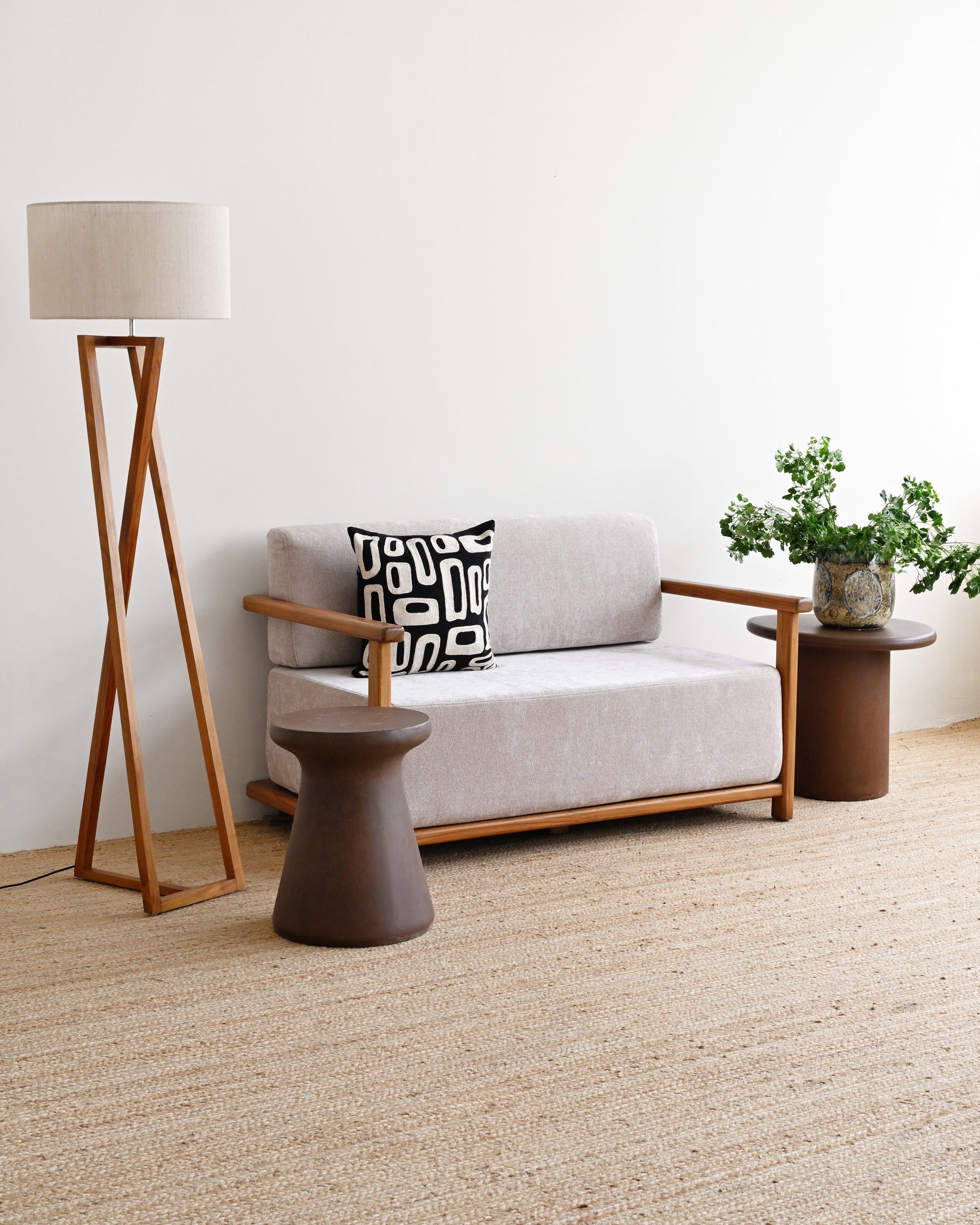 Modern living room with a gray sofa, wooden floor lamp, and side table.