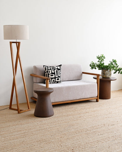 Modern living room with a gray sofa, wooden floor lamp, and side table.
