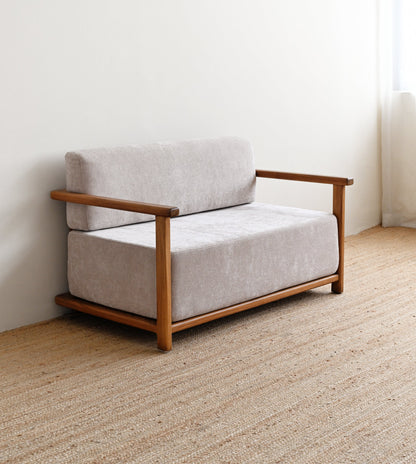 Small sofa with wooden frame and light gray cushions on a beige carpet.