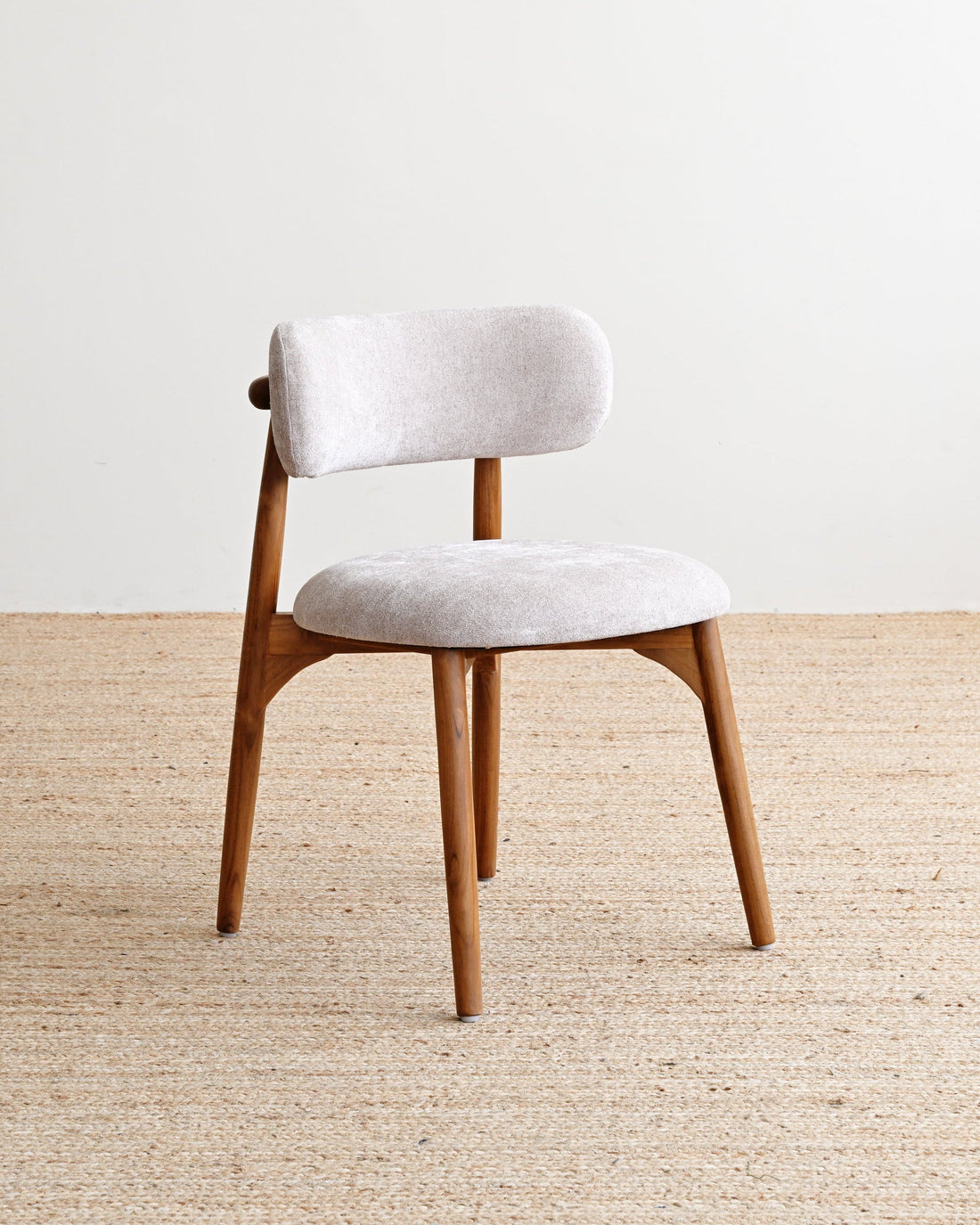 Chair with white cushioned seat and backrest on a beige carpet