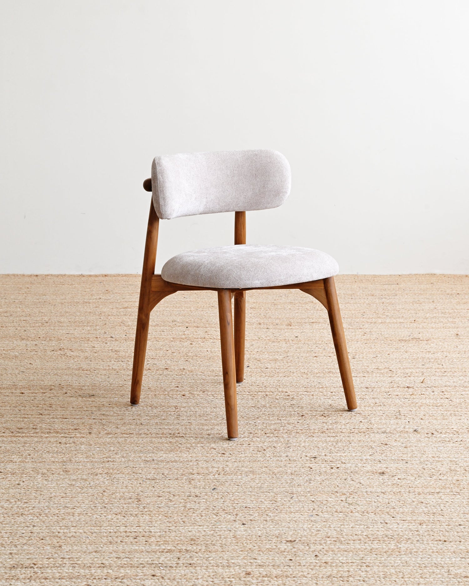 Chair with white cushioned seat and backrest on a beige carpet