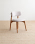 Chair with white cushioned seat and backrest on a beige carpet