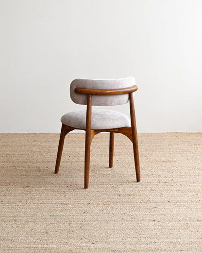 Wooden chair with a cushioned seat on a textured beige carpet