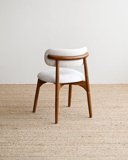 Wooden chair with white cushion on a beige carpet