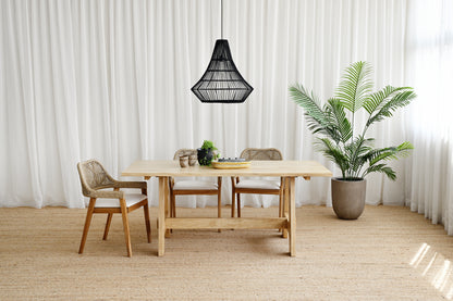 Dining area with wooden table and chairs, black pendant light, and potted plant.