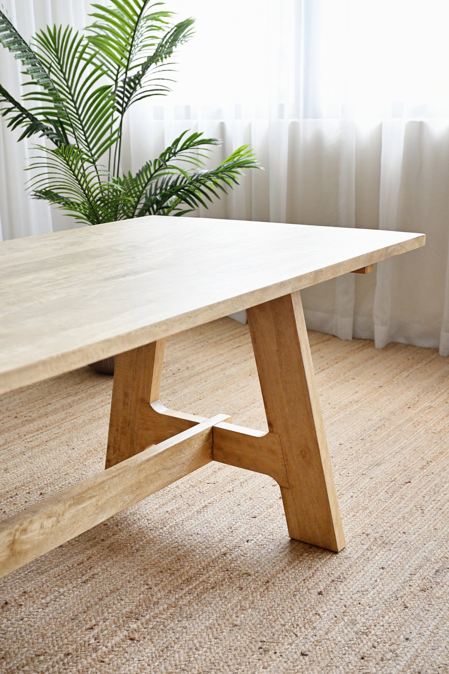 Wooden table with a plant in the background