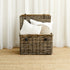 Wicker basket with white pillows against a white curtain background
