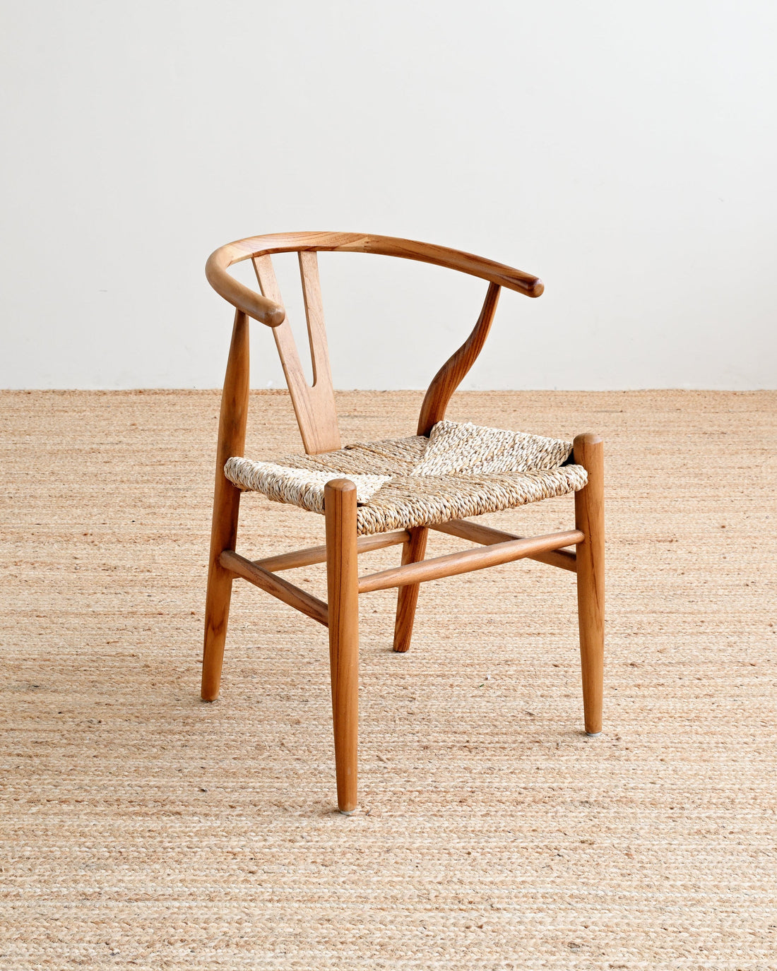 Wooden chair with woven seat on a wooden floor and white wall background