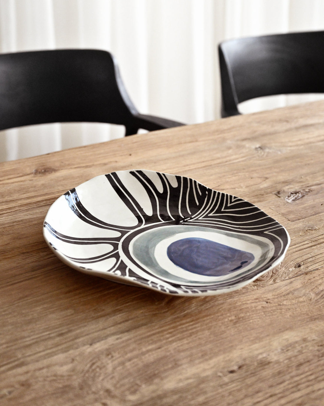 Decorative plate with black and white patterns on a wooden table
