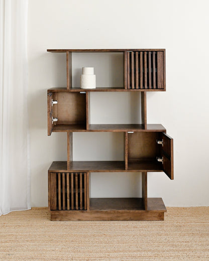 Wooden bookshelf with open doors against a white wall
