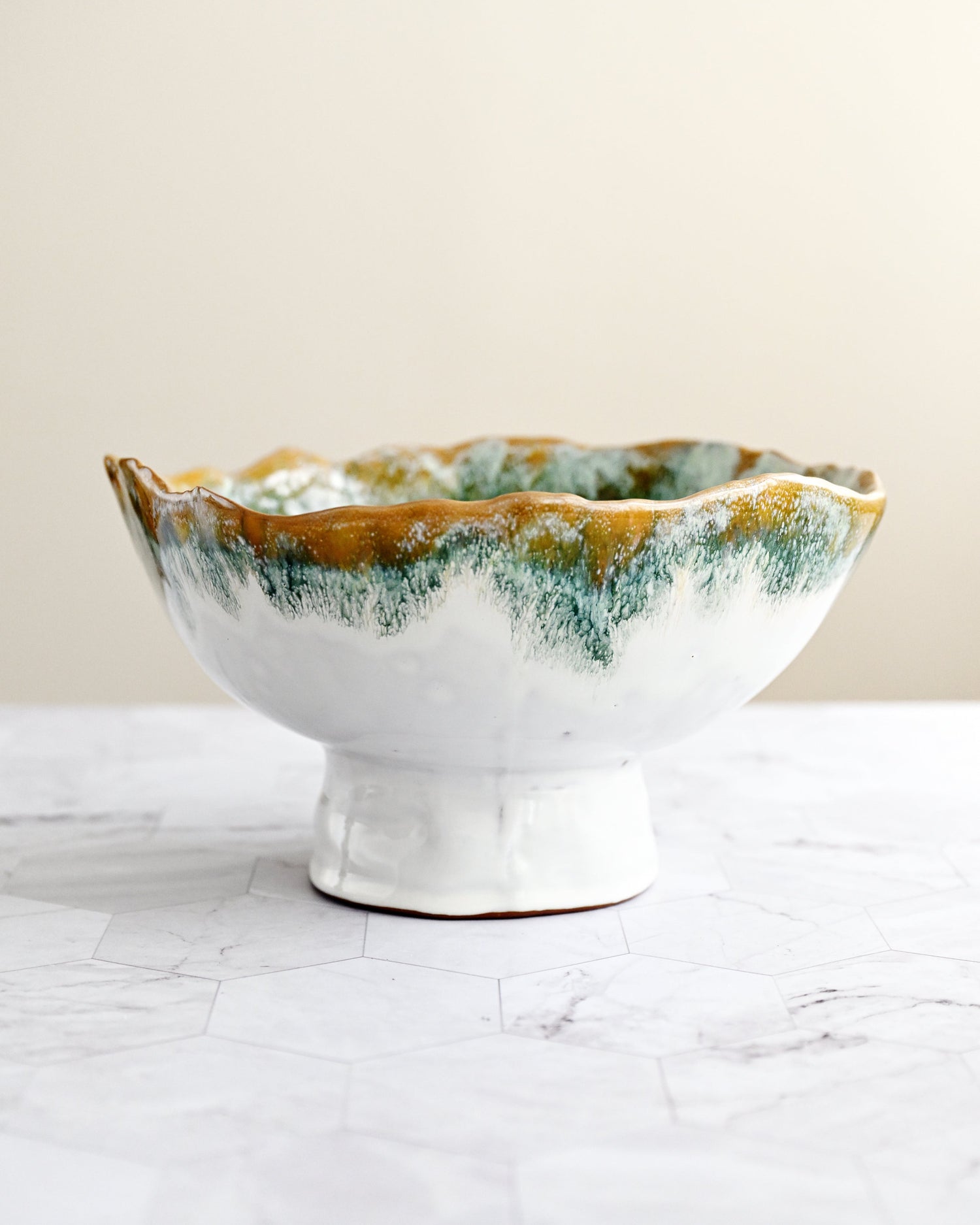 Ceramic bowl with green and brown glaze on a white surface