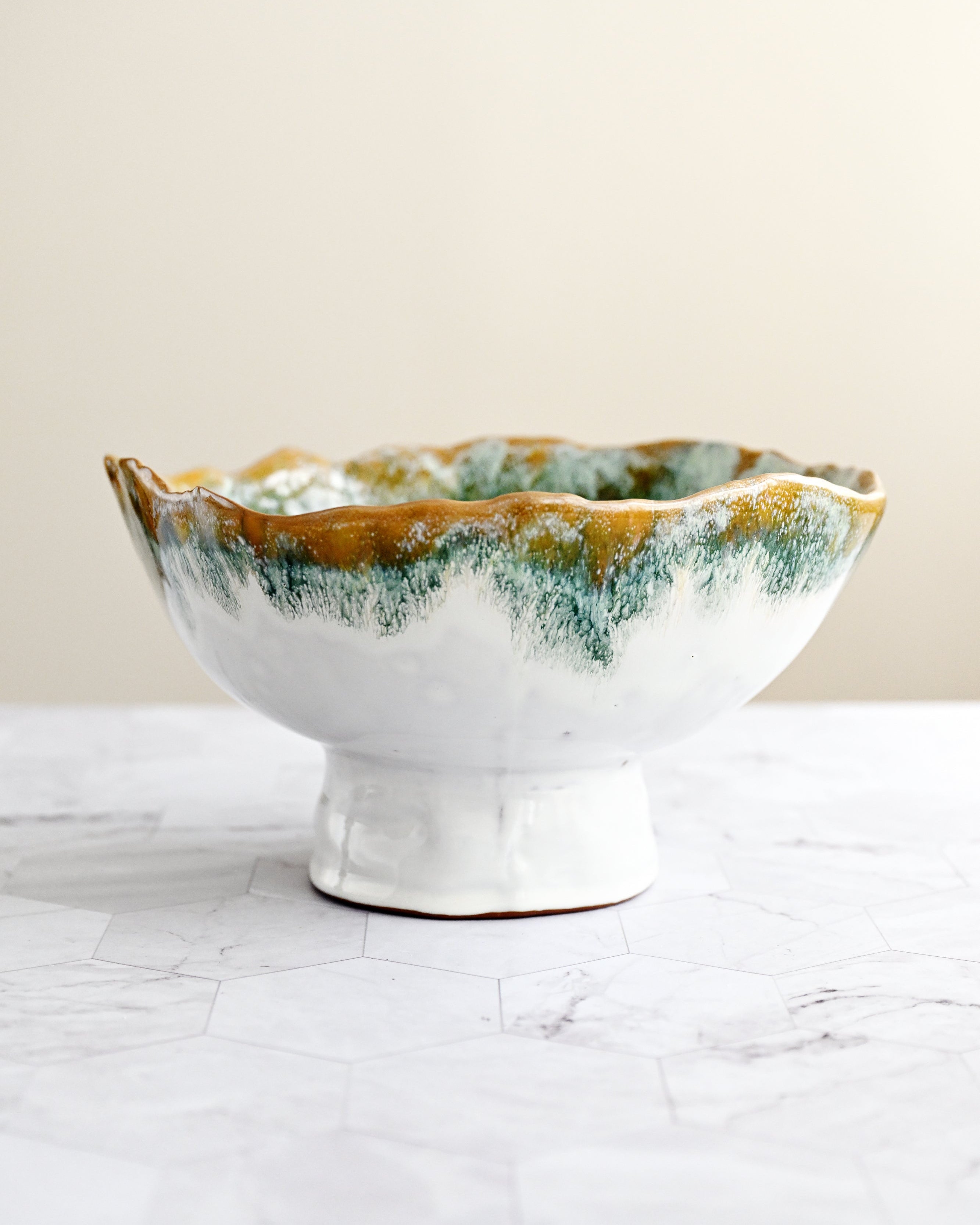 Ceramic bowl with green and brown glaze on a white surface