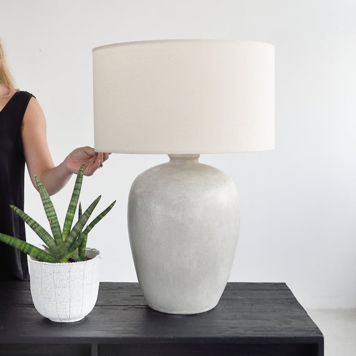 Woman holding stone table lamp by Island Living
